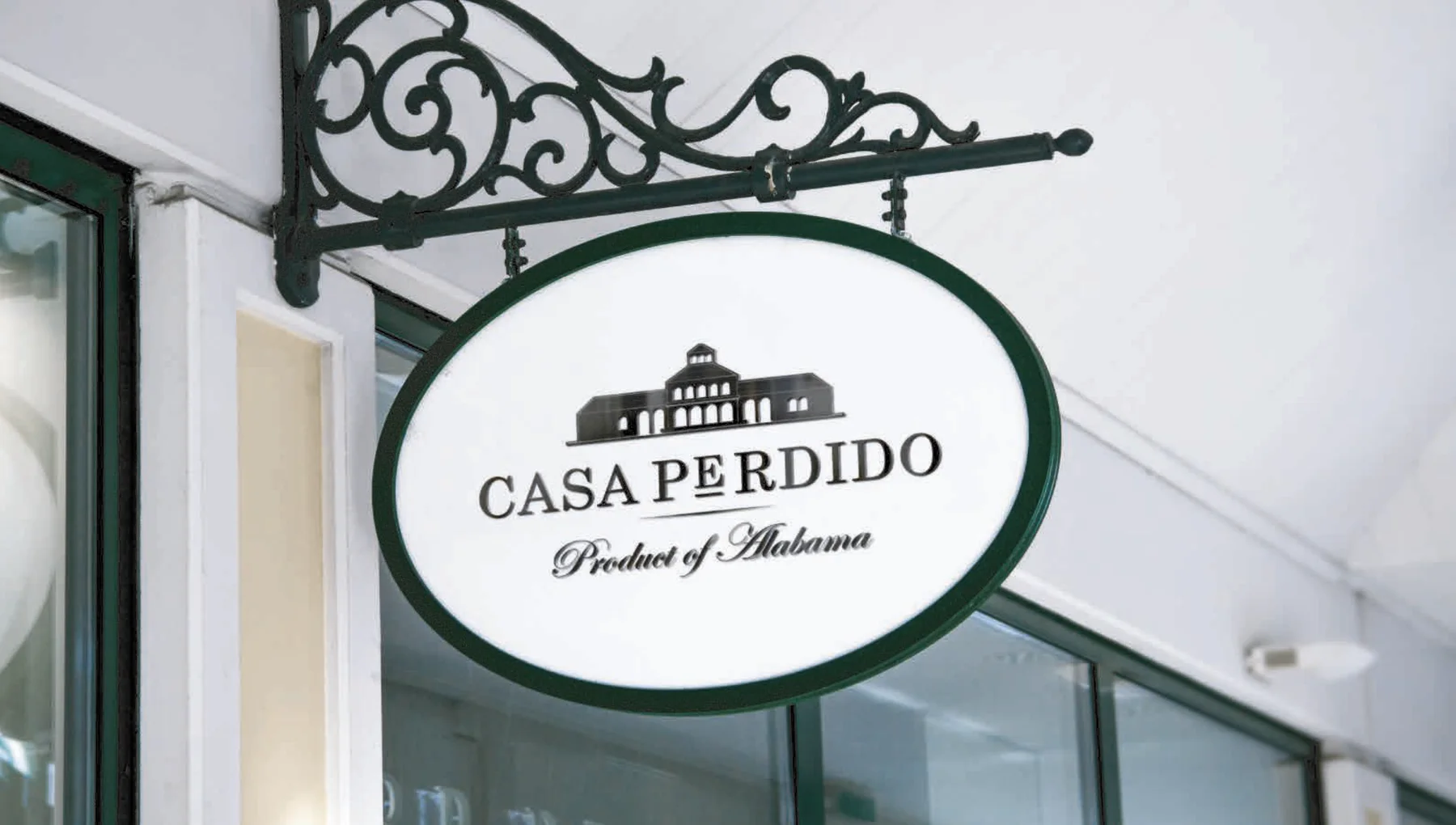 Logo Casa Perdido aplicado en un cartel exterior tipo wine bar — herrería negra y placa ovalada con la ilustración del edificio