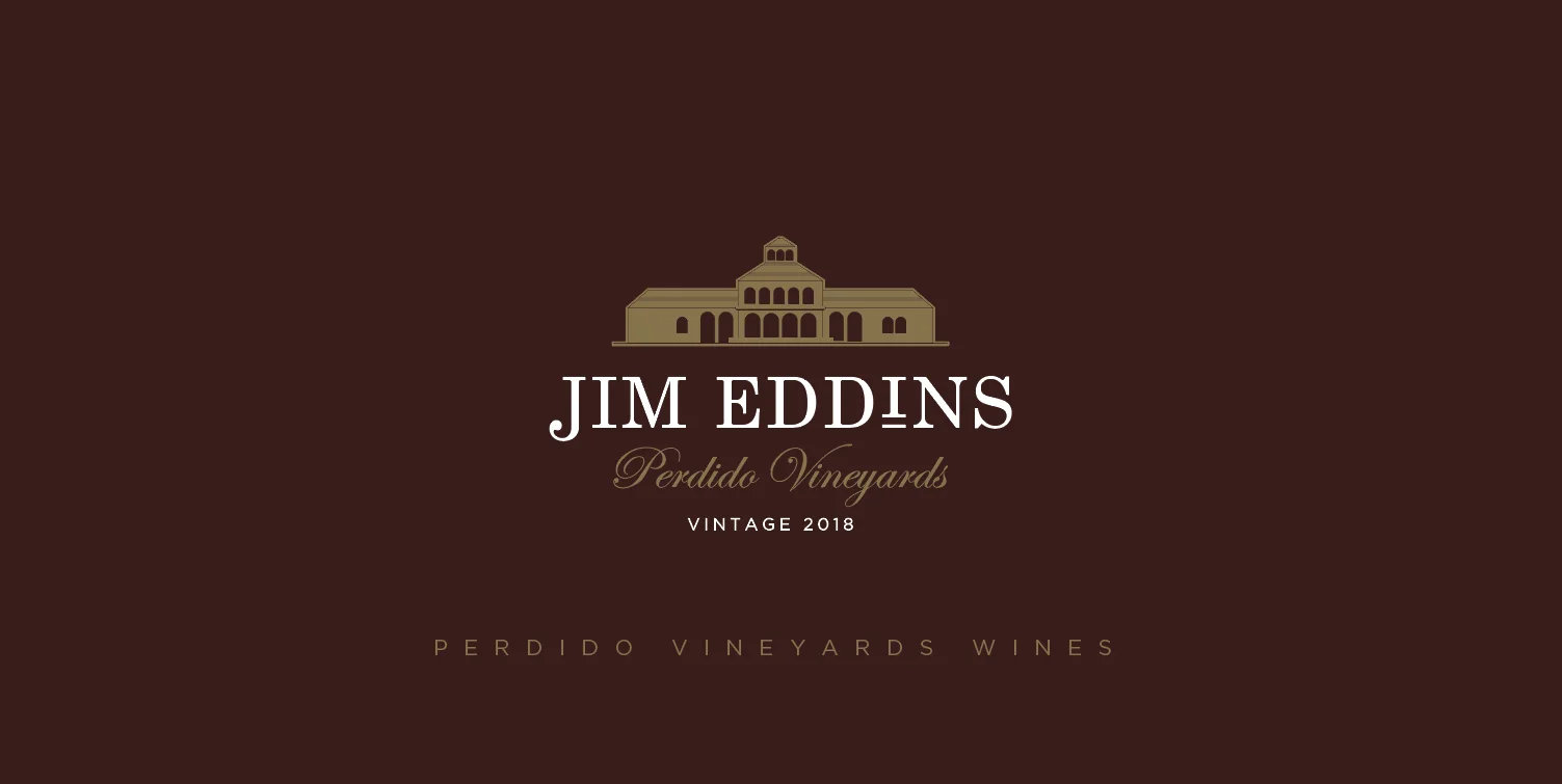 JIM EDDINS — Perdido Vineyards — Vintage 2018. Logotipo principal con ilustración dorada del edificio histórico sobre fondo burdeos.